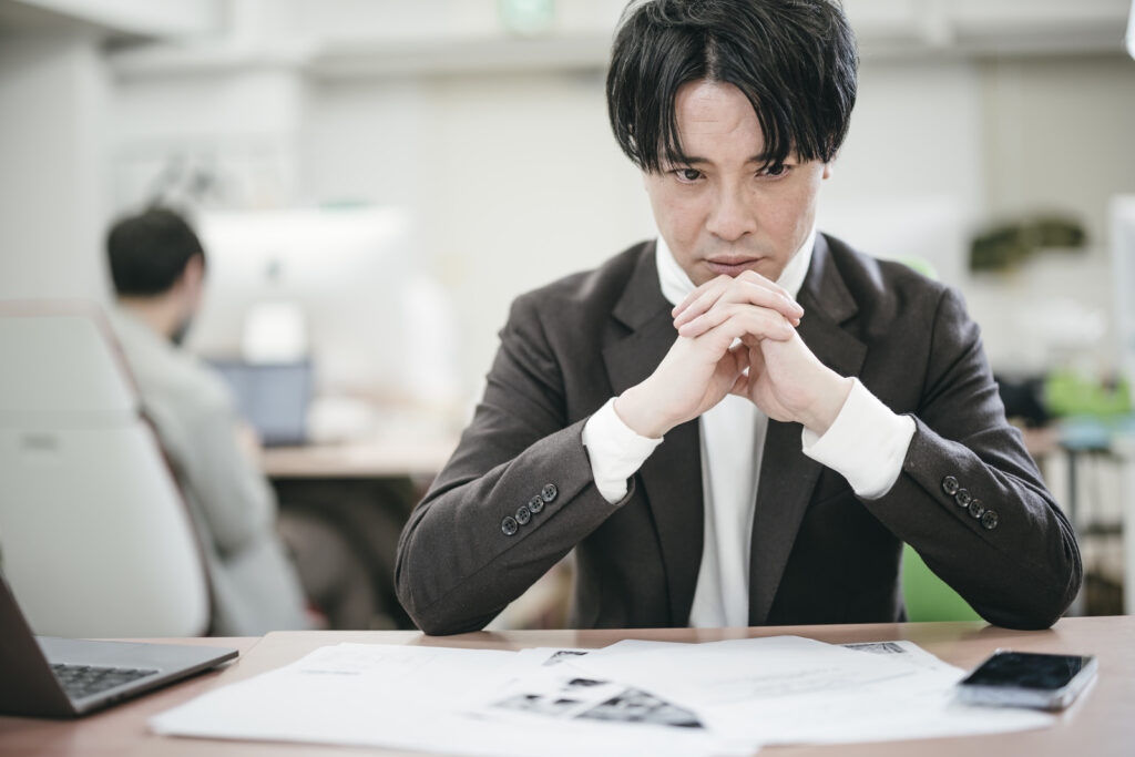デスクで悩む男性