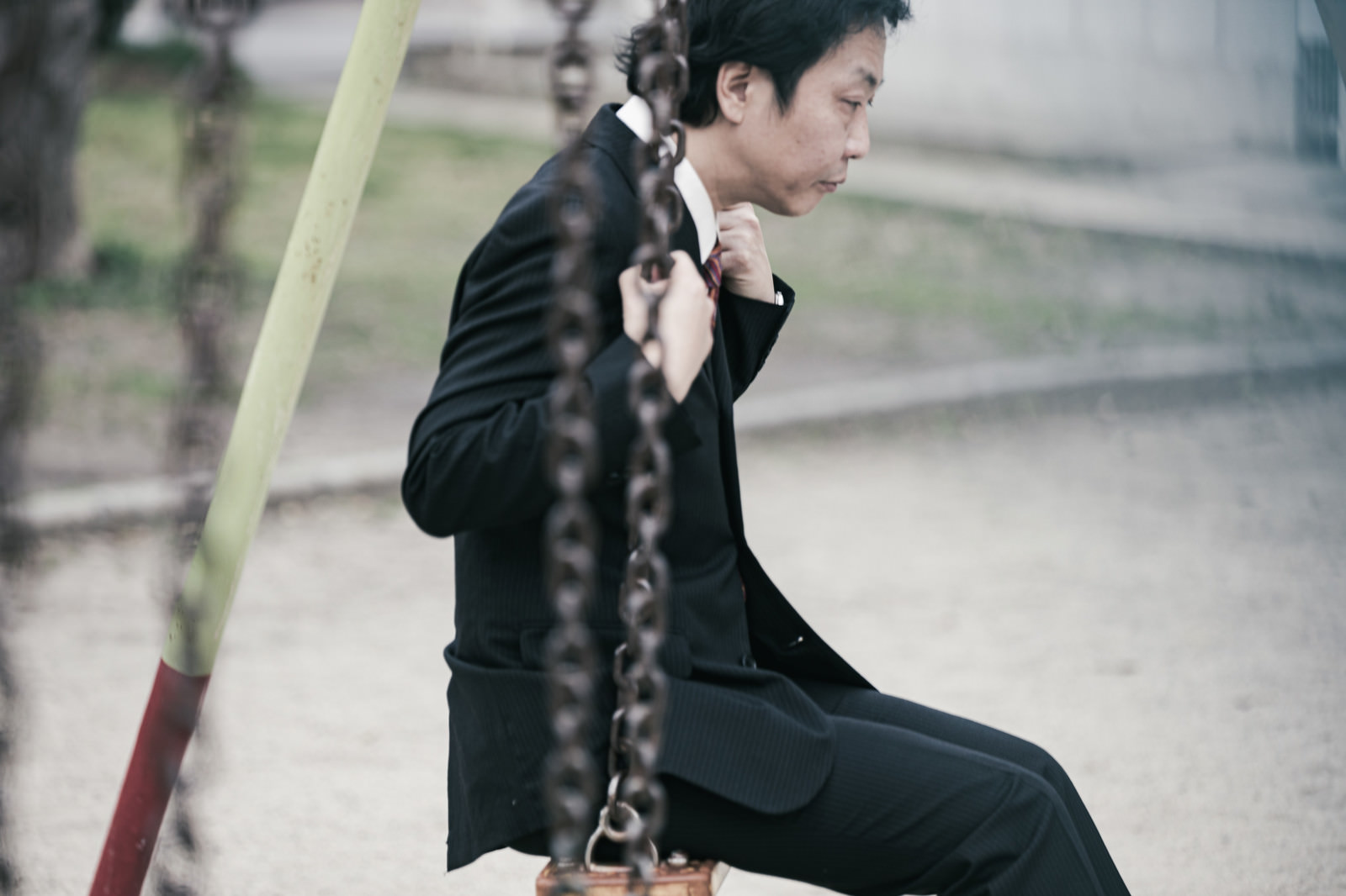 ブランコで黄昏ている男性